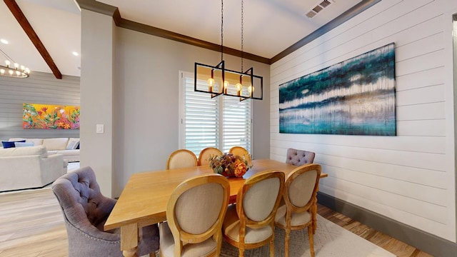 dining area with a chandelier, wood walls, light wood-style floors, recessed lighting, and baseboards
