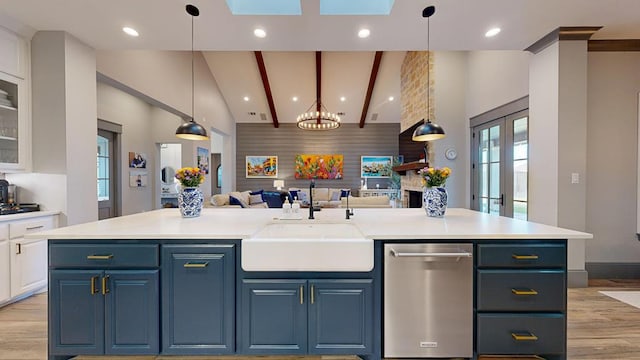 kitchen featuring a sink, dishwasher, open floor plan, blue cabinetry, and high vaulted ceiling