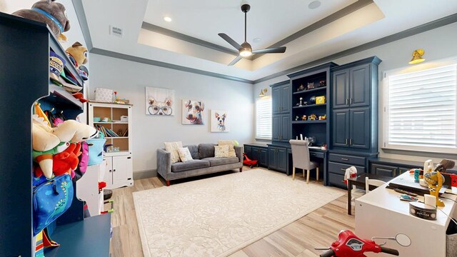 recreation room featuring a raised ceiling, a ceiling fan, light wood-type flooring, and recessed lighting