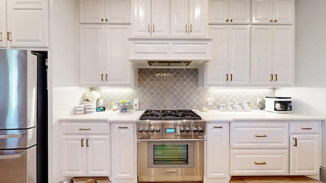 kitchen with appliances with stainless steel finishes, white cabinetry, and tasteful backsplash