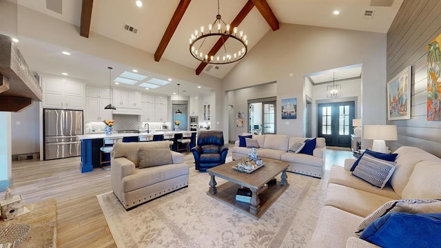 living room with high vaulted ceiling, a chandelier, light wood-type flooring, beamed ceiling, and recessed lighting