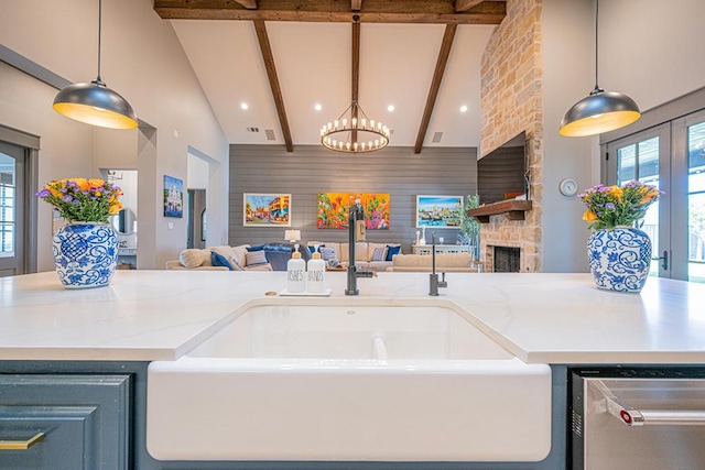 kitchen featuring open floor plan, a sink, high vaulted ceiling, dishwasher, and a chandelier