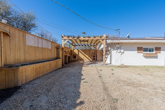 exterior space with concrete block siding, fence, and a pergola