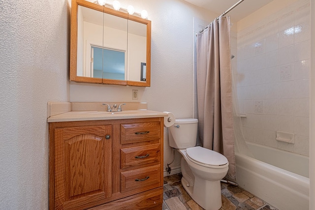 bathroom with a textured wall, toilet, stone tile floors, shower / tub combo, and vanity