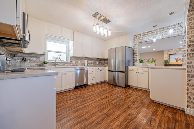 kitchen featuring white cabinets, dark wood-style floors, stainless steel appliances, and light countertops