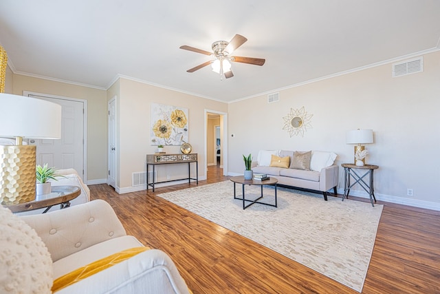 living area with baseboards, visible vents, and wood finished floors