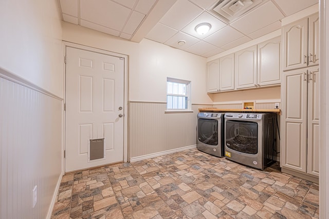 laundry room with cabinet space, baseboards, visible vents, a wainscoted wall, and independent washer and dryer