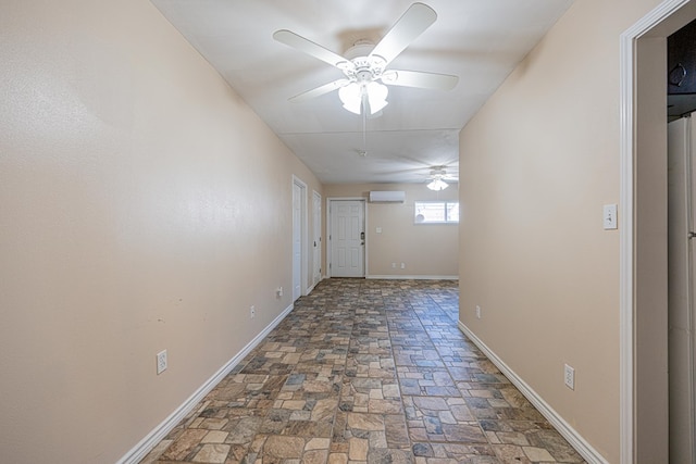 corridor with stone finish flooring, baseboards, and a wall mounted AC