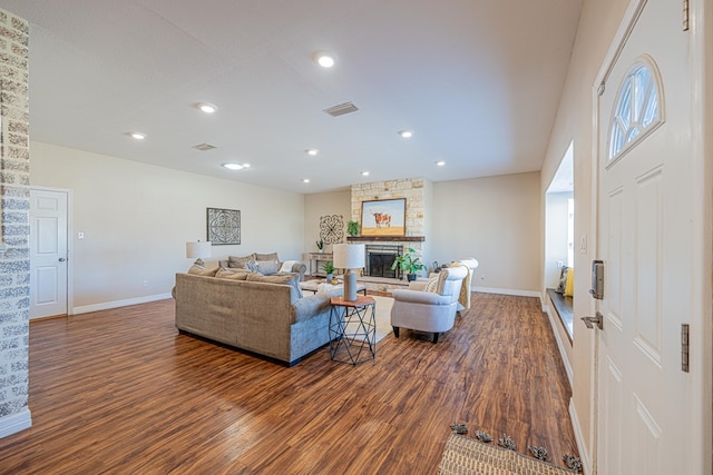 living room with dark wood-style floors, a fireplace, visible vents, and baseboards