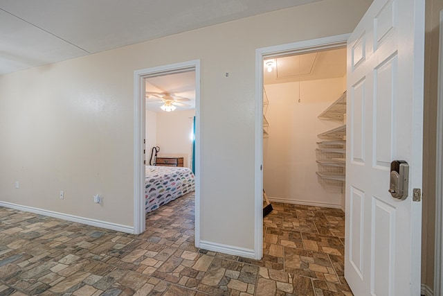 interior space with stone finish flooring, attic access, and baseboards