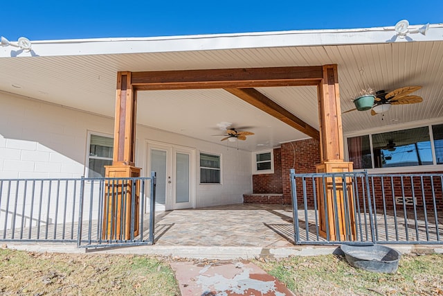 property entrance with a ceiling fan, concrete block siding, and covered porch