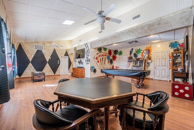 recreation room with a paneled ceiling, ceiling fan, visible vents, and wood finished floors