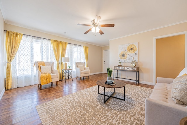 living room with crown molding, baseboards, and wood finished floors