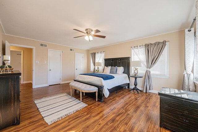 bedroom with visible vents, crown molding, and wood finished floors