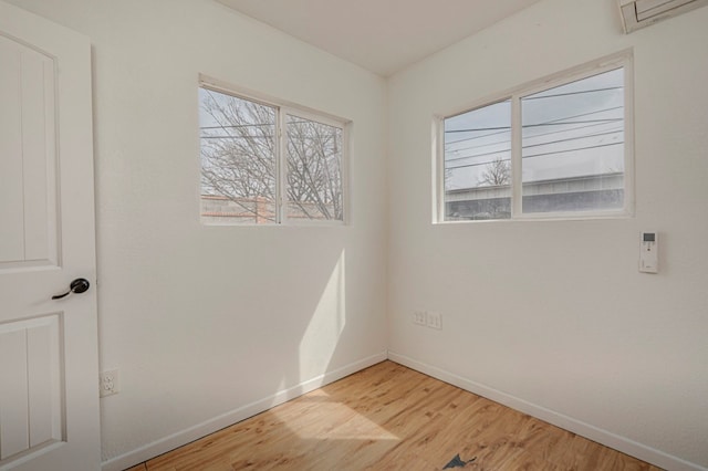 empty room with light wood-style flooring, a wealth of natural light, and baseboards