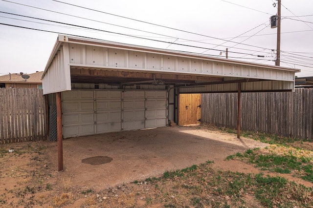 garage with fence and a carport