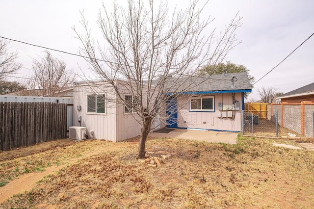 back of property with ac unit and a fenced backyard