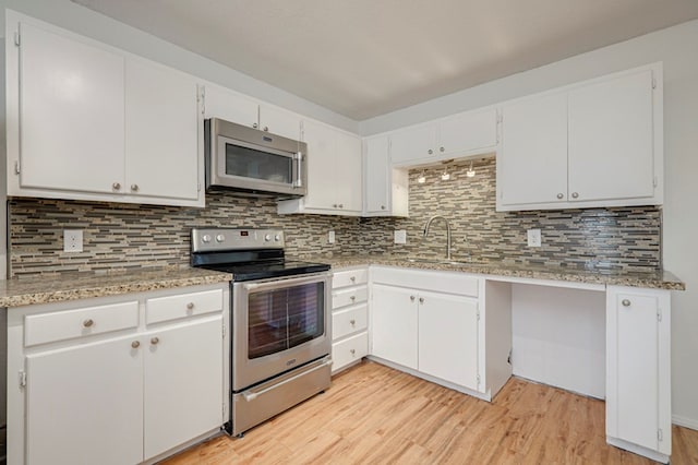 kitchen with light wood-style floors, tasteful backsplash, white cabinetry, and stainless steel appliances