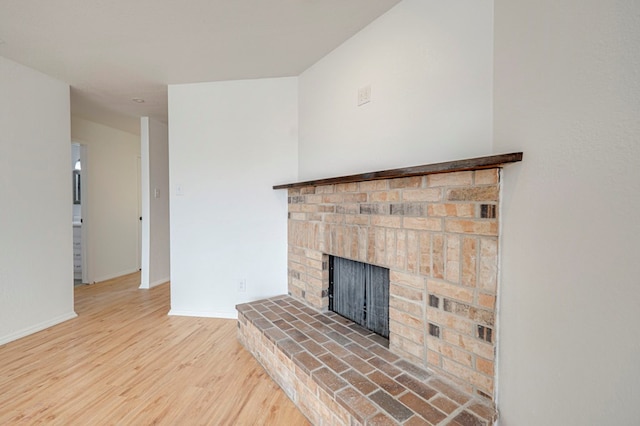 details featuring a fireplace, wood finished floors, and baseboards