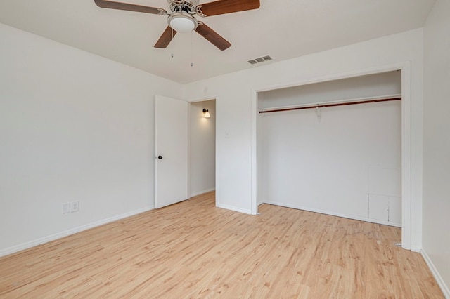 unfurnished bedroom featuring a closet, visible vents, ceiling fan, wood finished floors, and baseboards