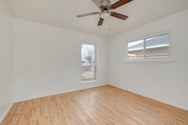 spare room with a ceiling fan, baseboards, and light wood finished floors