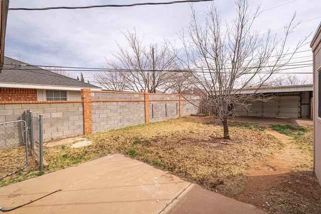 view of yard featuring a garage, a fenced backyard, and a patio