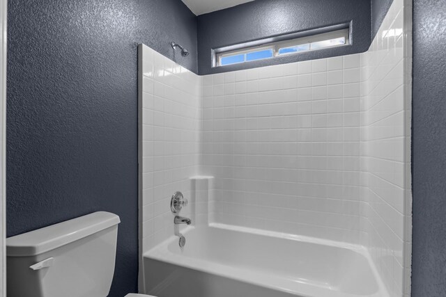 bathroom featuring tub / shower combination and toilet