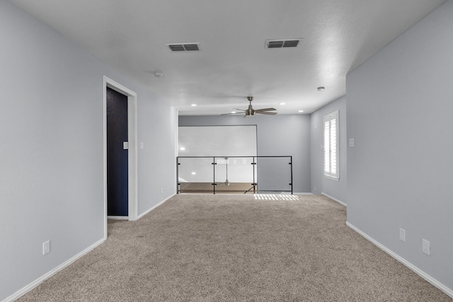 spare room featuring light colored carpet and ceiling fan