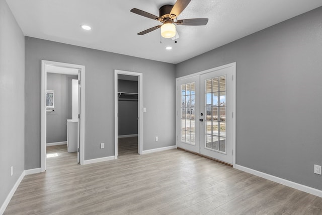 1344 E 5th St, Odessa, TX 79761 - unfurnished bedroom with french doors, access to outside, light wood-type flooring, a walk in closet, and baseboards