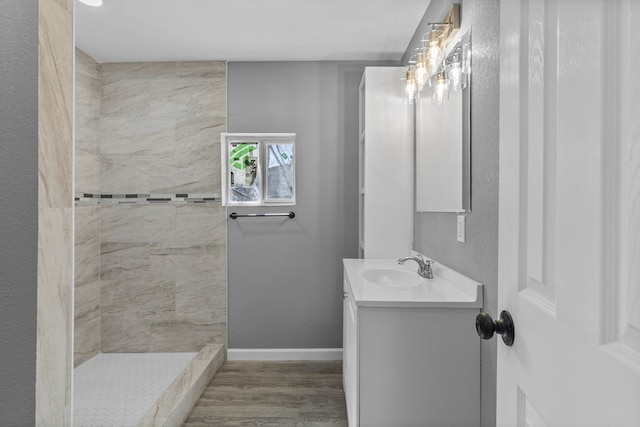 1344 E 5th St, Odessa, TX 79761 - full bath featuring vanity, tiled shower, baseboards, and wood finished floors
