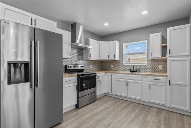 1344 E 5th St, Odessa, TX 79761 - kitchen with stainless steel appliances, wall chimney exhaust hood, a sink, wood counters, and white cabinetry