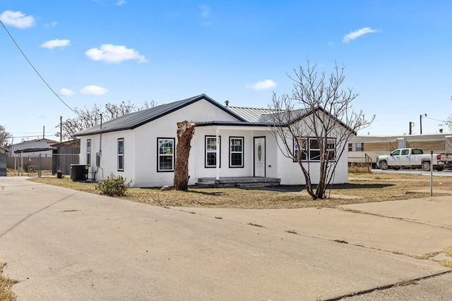 1344 E 5th St, Odessa, TX 79761 - view of front of home featuring central AC, stucco siding, metal roof, and concrete driveway