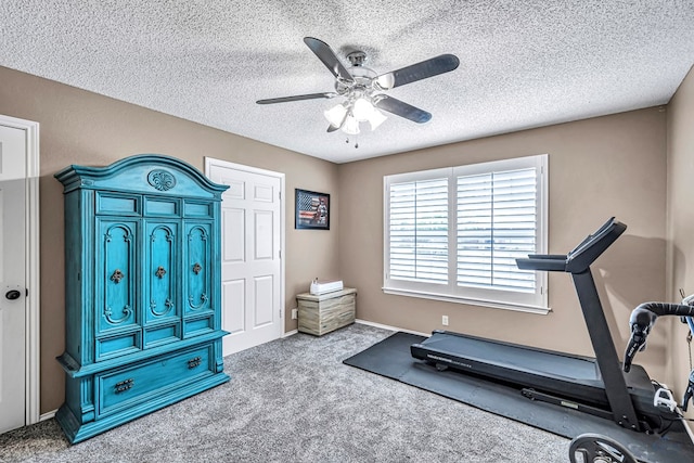 exercise room featuring a ceiling fan, carpet flooring, and a textured ceiling