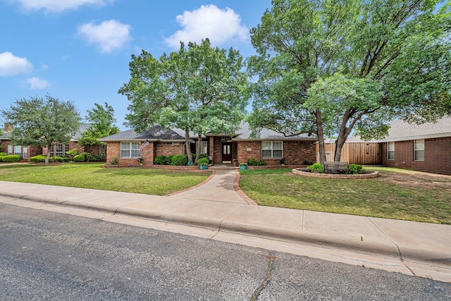 single story home featuring brick siding and a front lawn