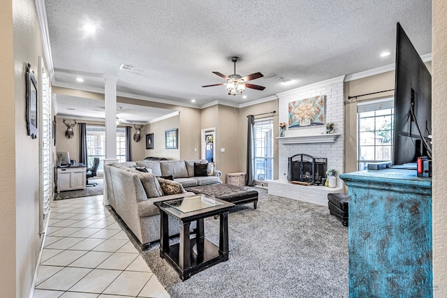 living room featuring crown molding, healthy amount of natural light, ceiling fan, a textured ceiling, and a brick fireplace