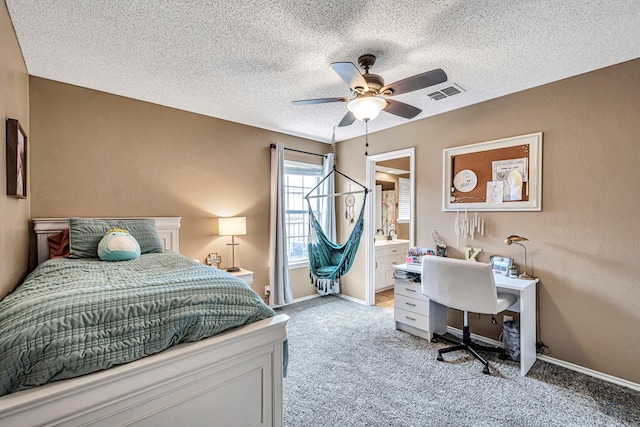 bedroom featuring a textured ceiling, light carpet, baseboards, connected bathroom, and a ceiling fan