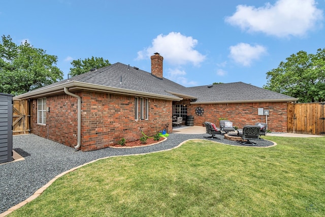 back of house featuring a chimney, a patio, a shingled roof, a gate, and brick siding
