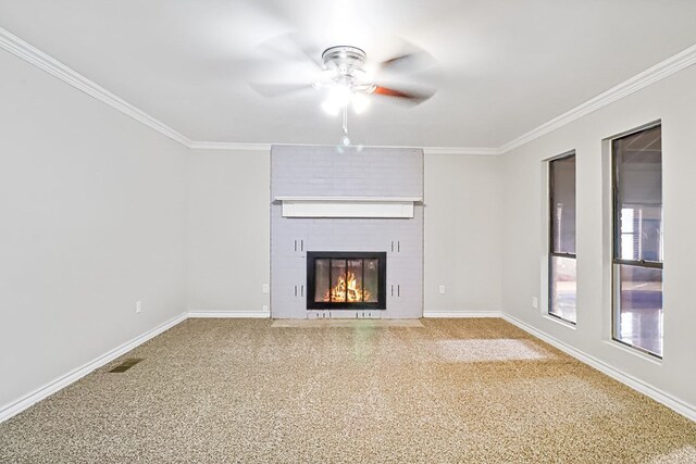 unfurnished living room with carpet, ceiling fan, crown molding, and a fireplace