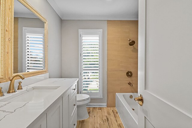 full bathroom featuring wood-type flooring, vanity, toilet, and tiled shower / bath