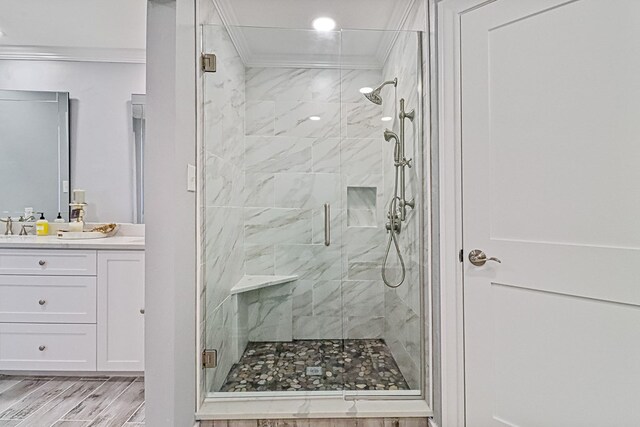 bathroom featuring crown molding, vanity, wood-type flooring, and an enclosed shower