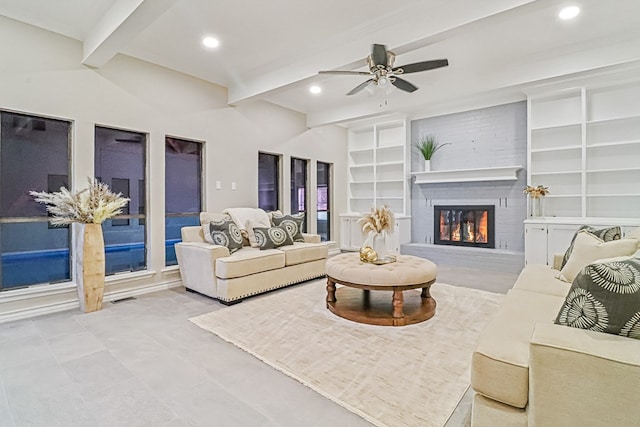 living room featuring built in shelves, ceiling fan, a fireplace, and beamed ceiling