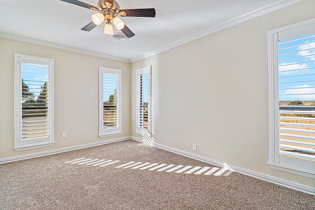 carpeted spare room featuring a wealth of natural light, crown molding, and ceiling fan