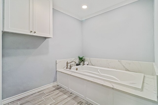 bathroom with hardwood / wood-style floors, a tub to relax in, and crown molding