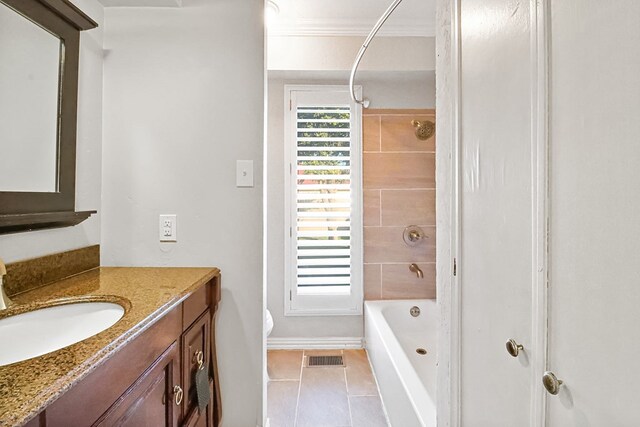 full bathroom with tile patterned floors, ornamental molding, tiled shower / bath combo, vanity, and toilet