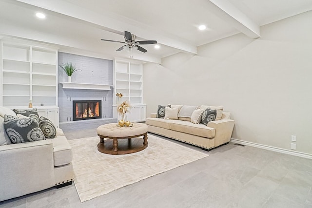 living room with ceiling fan, beam ceiling, built in shelves, and a brick fireplace