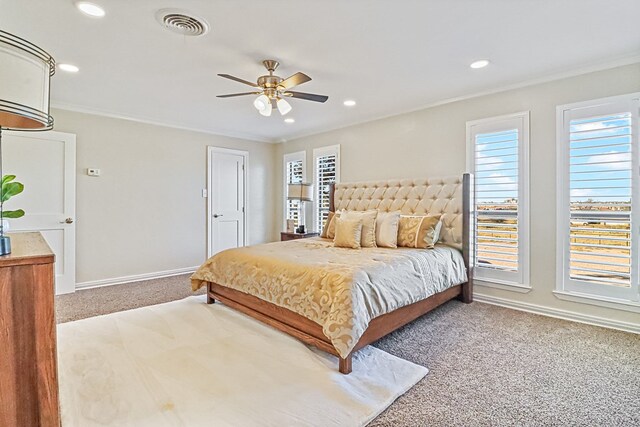 carpeted bedroom featuring ceiling fan and crown molding