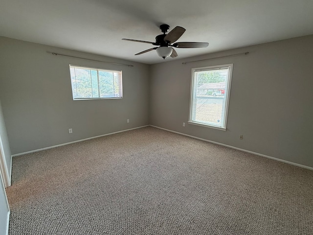 spare room with healthy amount of natural light, carpet, ceiling fan, and baseboards