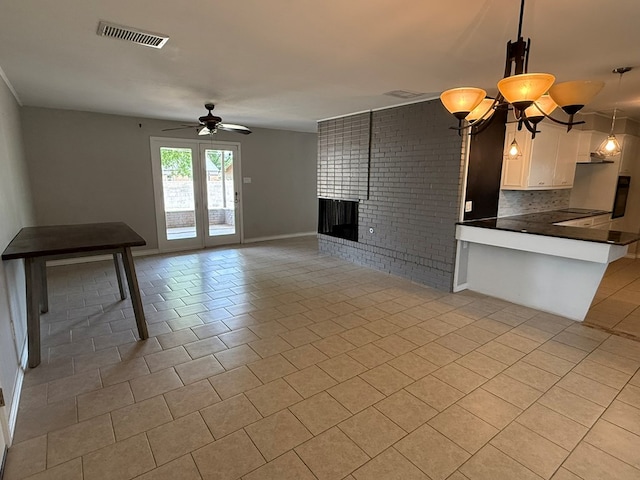 unfurnished living room with a ceiling fan, light tile patterned floors, a brick fireplace, and baseboards