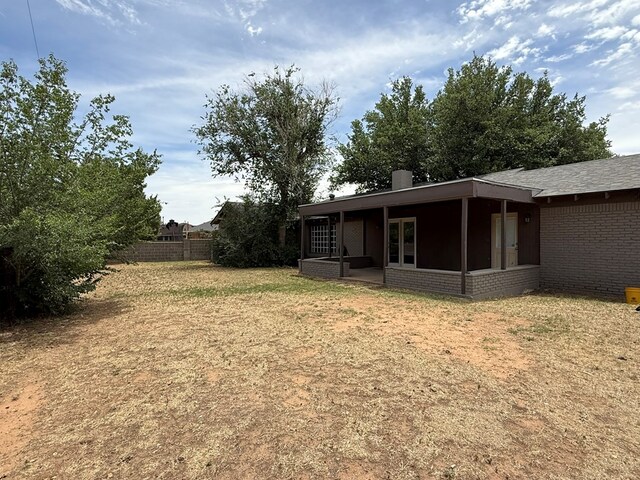 view of yard with a sunroom and fence