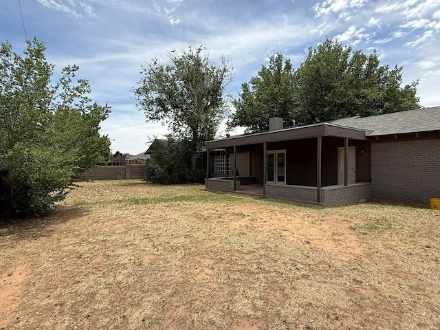 view of yard featuring a sunroom and fence
